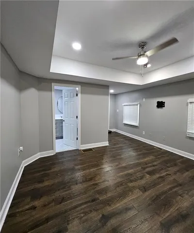 a view of an empty room with window and wooden floor