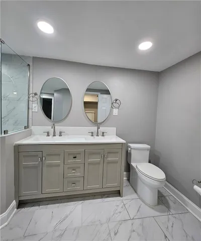 a bathroom with a double vanity sink and a toilet