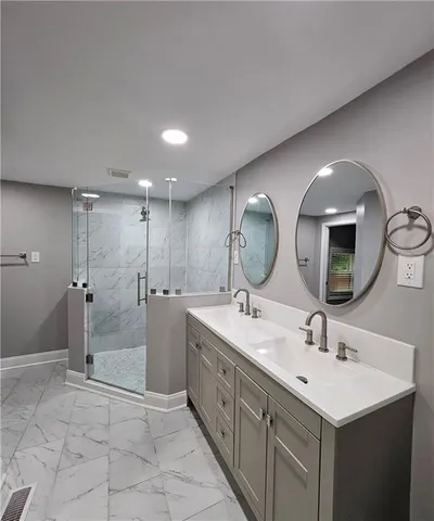 a bathroom with a double vanity sink mirror and shower