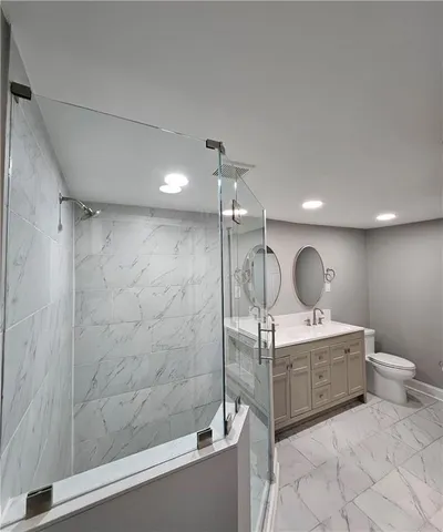 a spacious bathroom with a mirror a toilet and a shower