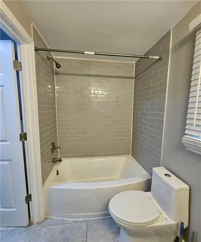 a bathroom with a toilet and a bath tub