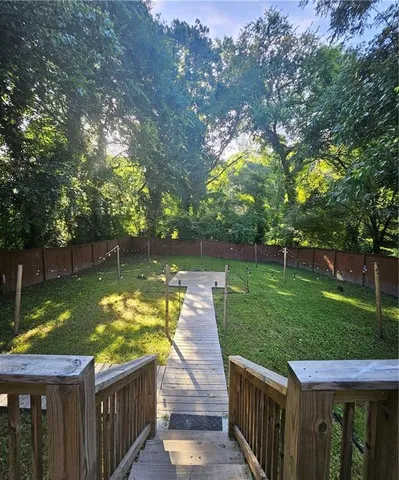 a view of a wooden deck and lake with trees in the background