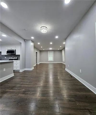 a view of empty room with wooden floor