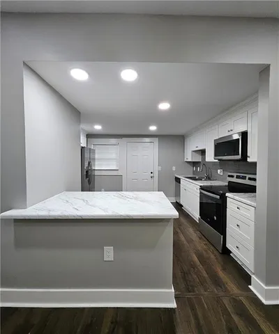 a kitchen with kitchen island sink stove and refrigerator