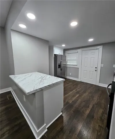 a kitchen view with wooden floor cabinetry and entryway