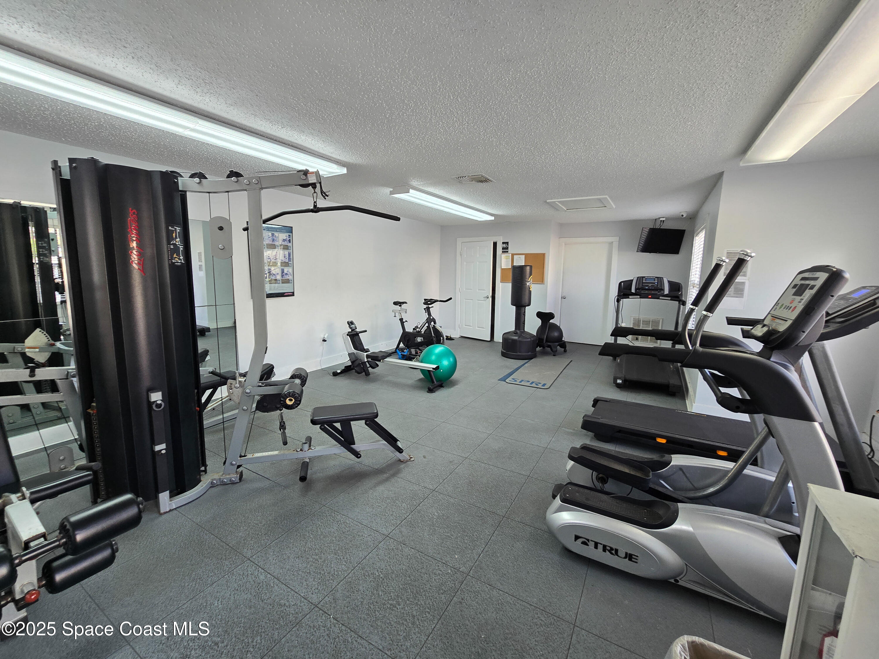 225 South Tropical Trail, Unit 217 Merritt Island, FL 32952 - Photo 11 of 18 a room with gym equipment and a mirror