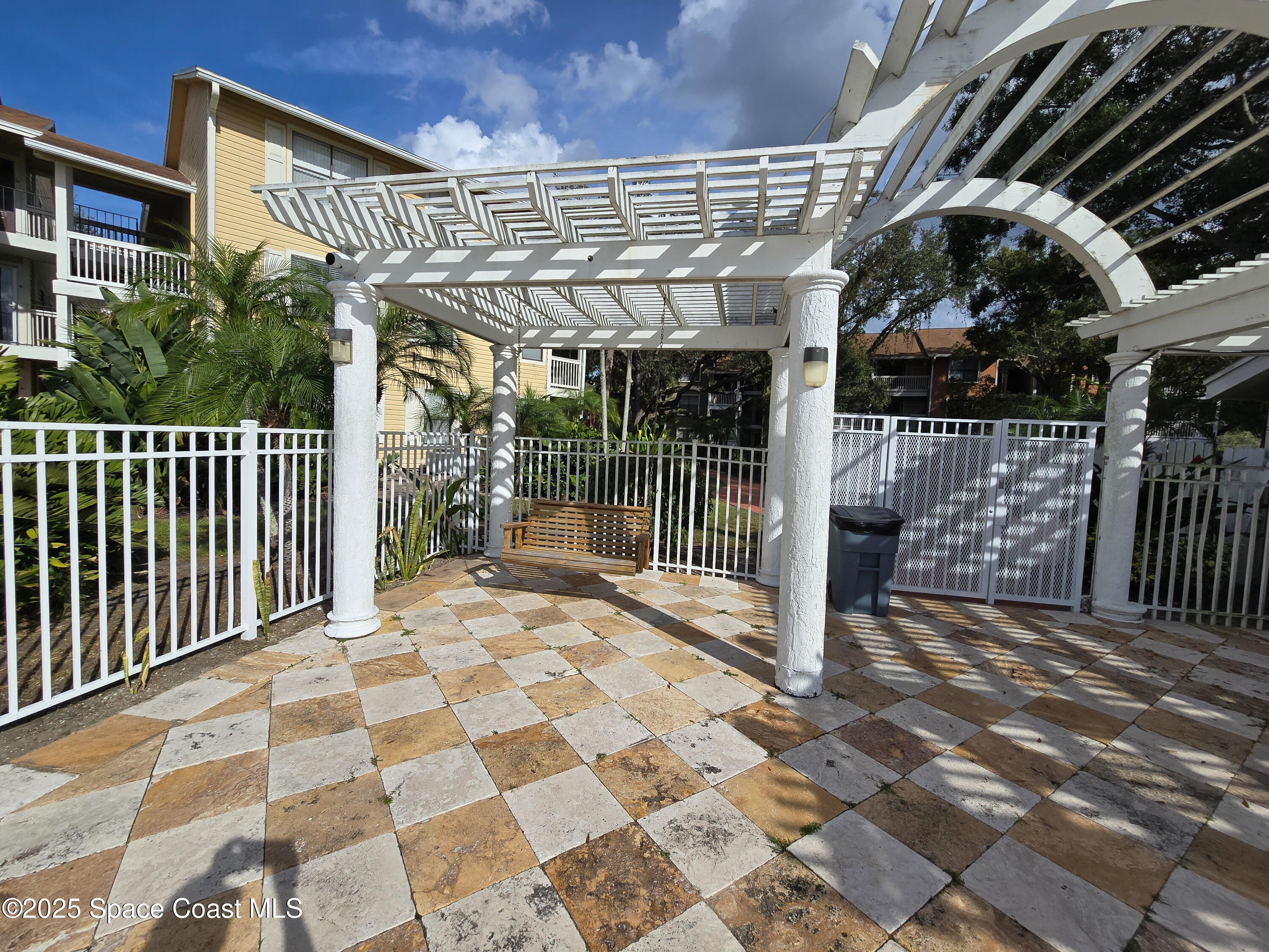 225 South Tropical Trail, Unit 217 Merritt Island, FL 32952 - Photo 14 of 18 a view of a patio with wooden fence and floor