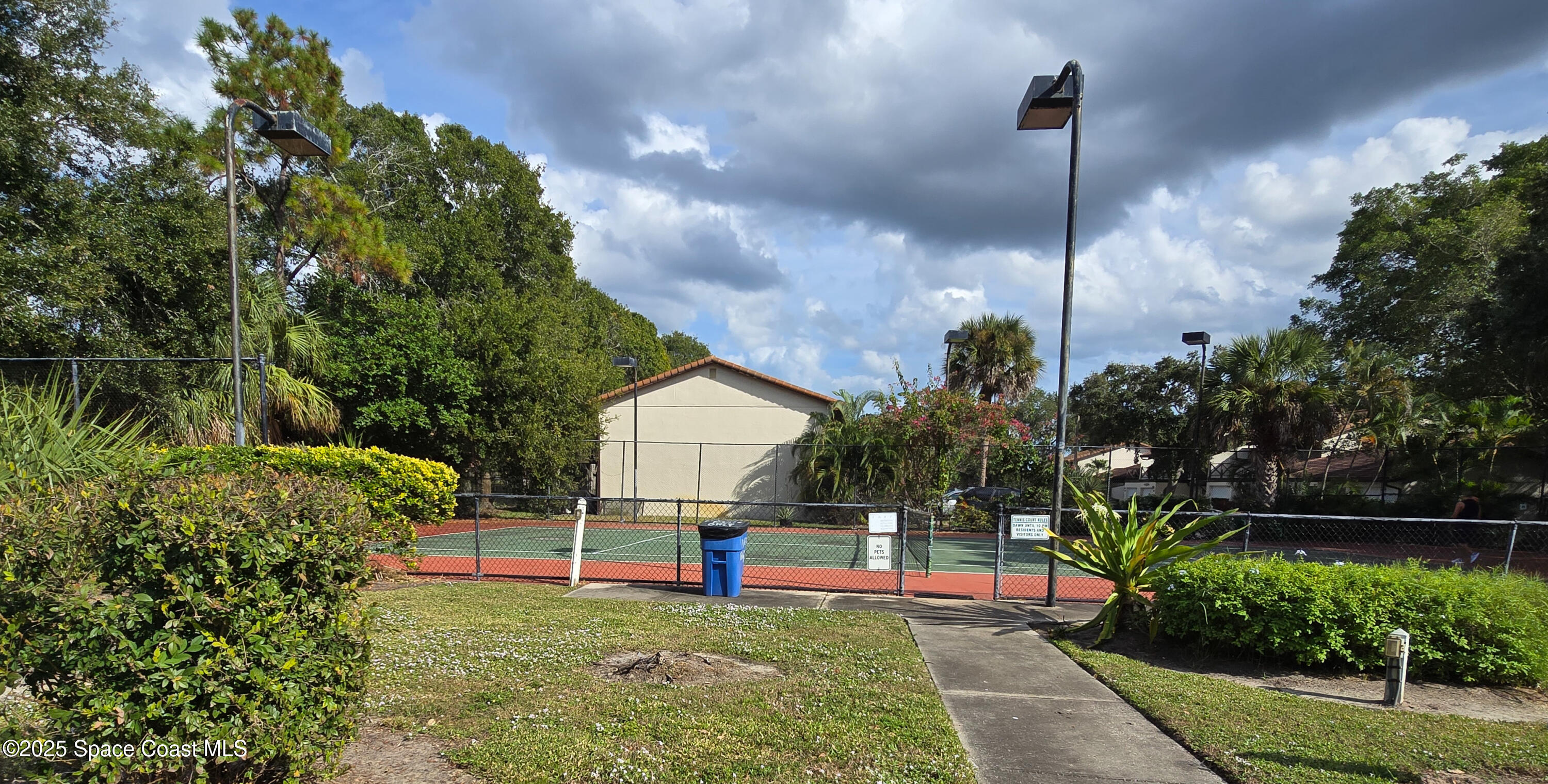 225 South Tropical Trail, Unit 217 Merritt Island, FL 32952 - Photo 18 of 18 a view of a backyard with plants and brick wall