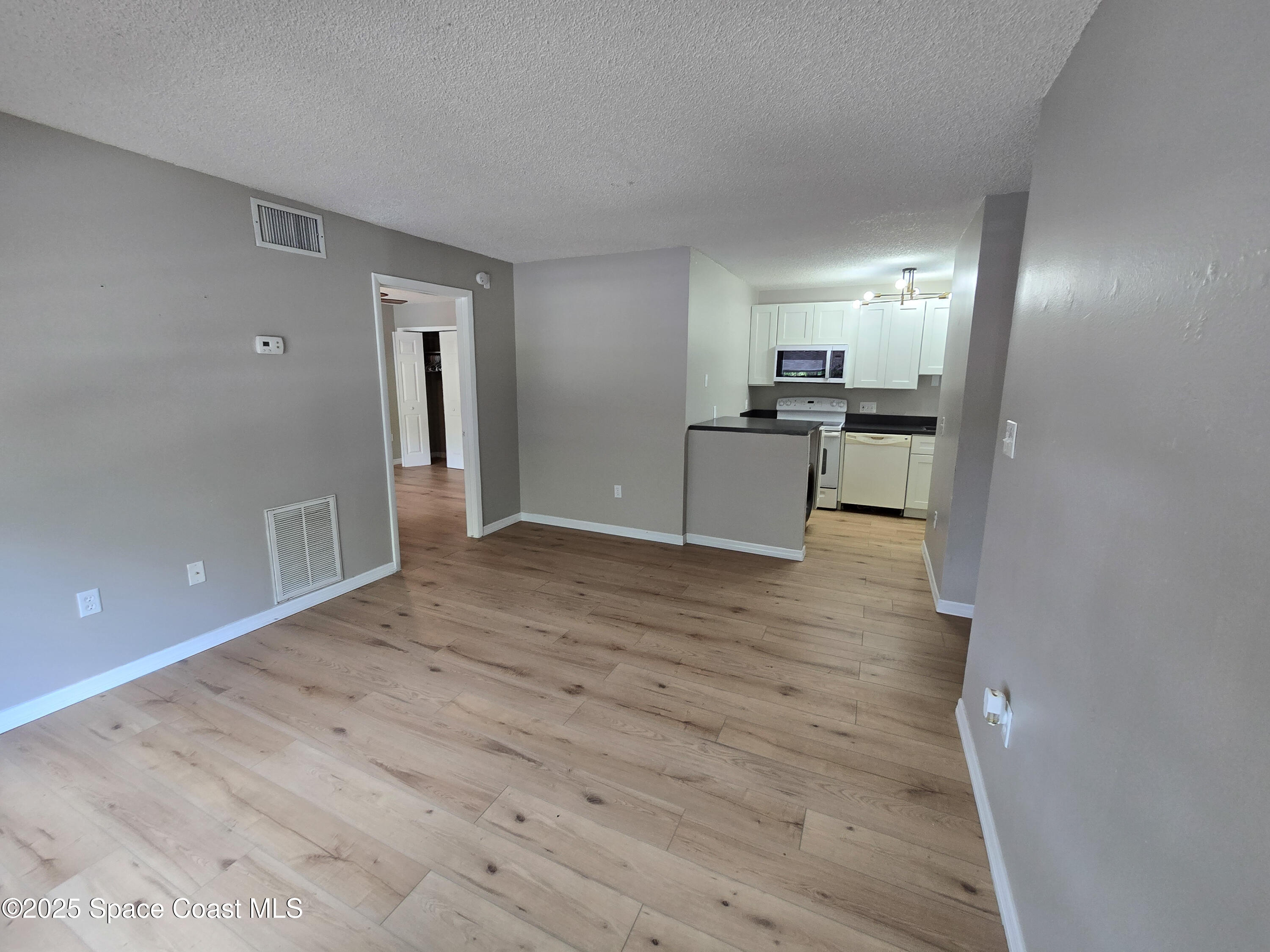 225 South Tropical Trail, Unit 217 Merritt Island, FL 32952 - Photo 4 of 18 a view of a kitchen cabinets and wooden floor