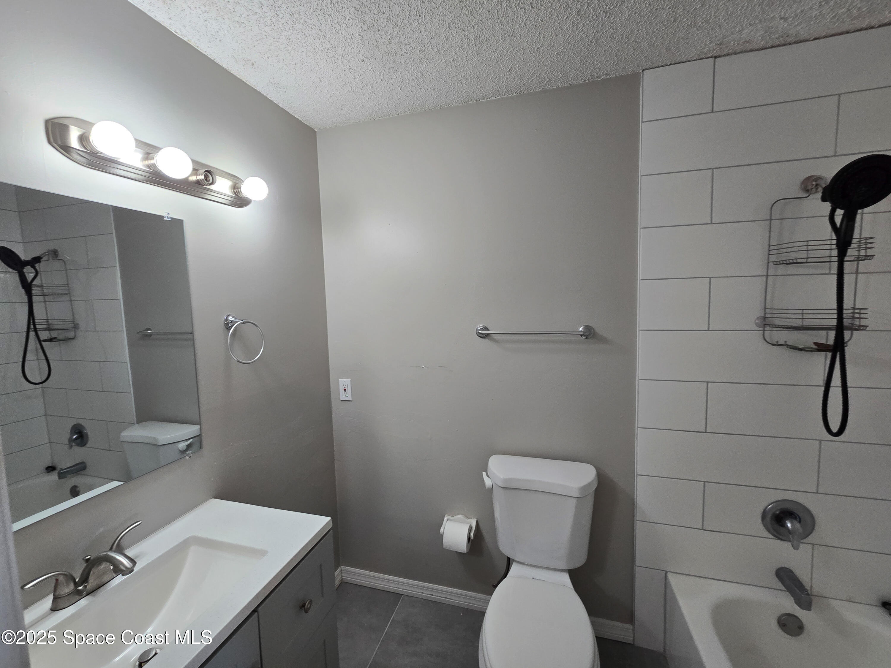 225 South Tropical Trail, Unit 217 Merritt Island, FL 32952 - Photo 8 of 18 a bathroom with a sink a toilet and shower