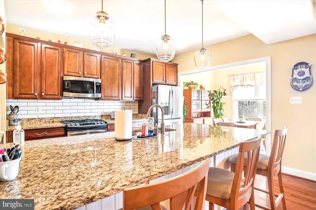 a kitchen with kitchen island granite countertop a stove top oven microwave and cabinets