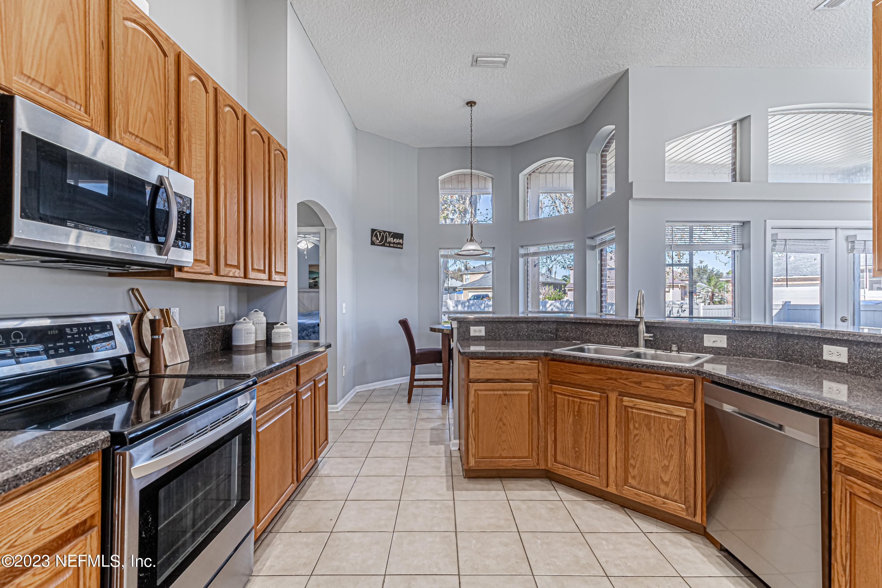 3795 Bedford Drive Middleburg, FL 32068 - Photo 14 of 54 a kitchen with stainless steel appliances granite countertop a stove top oven a sink dishwasher and cabinets