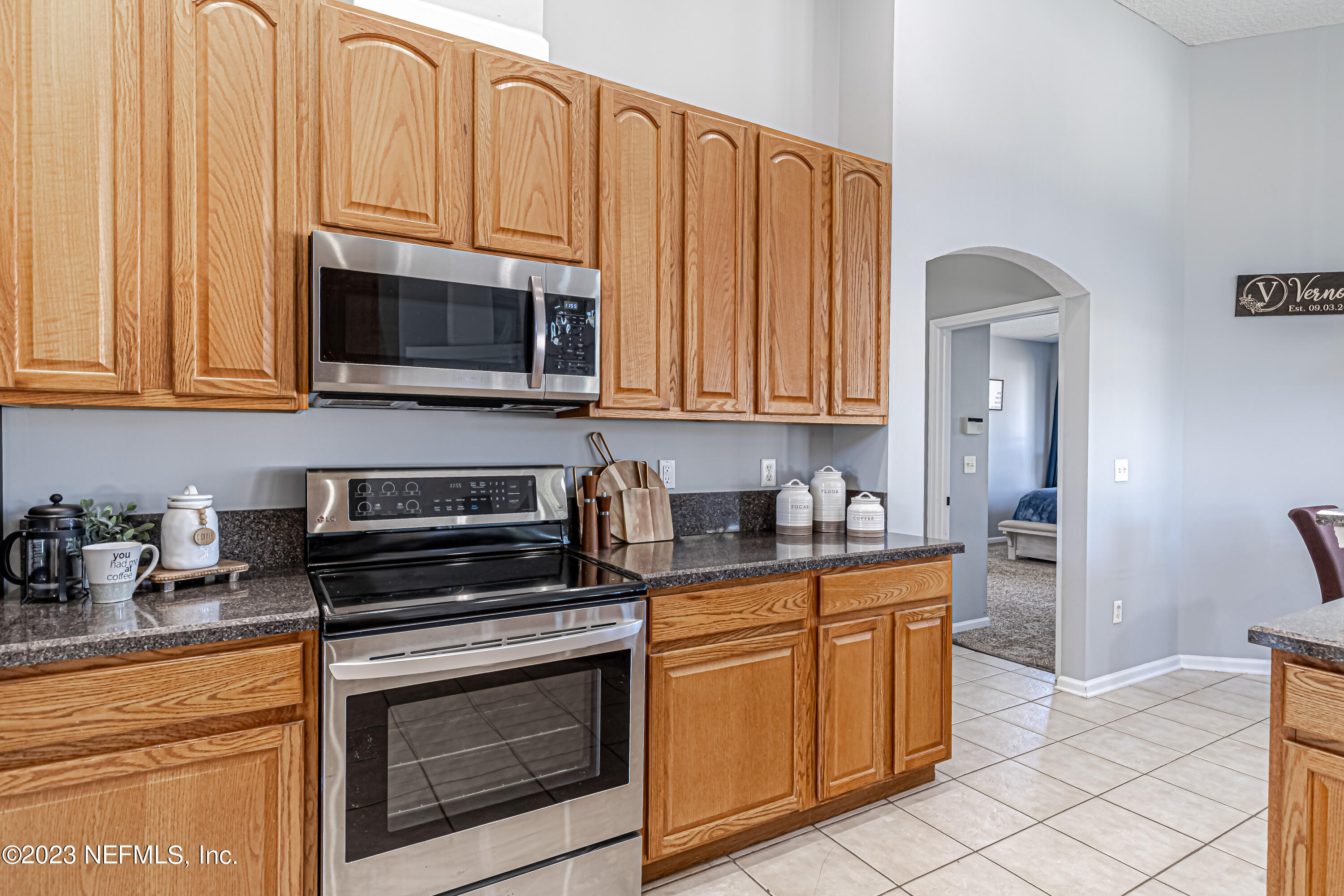 3795 Bedford Drive Middleburg, FL 32068 - Photo 16 of 54 a kitchen with granite countertop a stove top oven microwave and cabinets