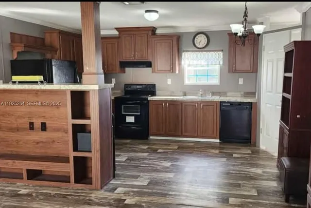 a kitchen with kitchen island granite countertop a stove refrigerator and microwave
