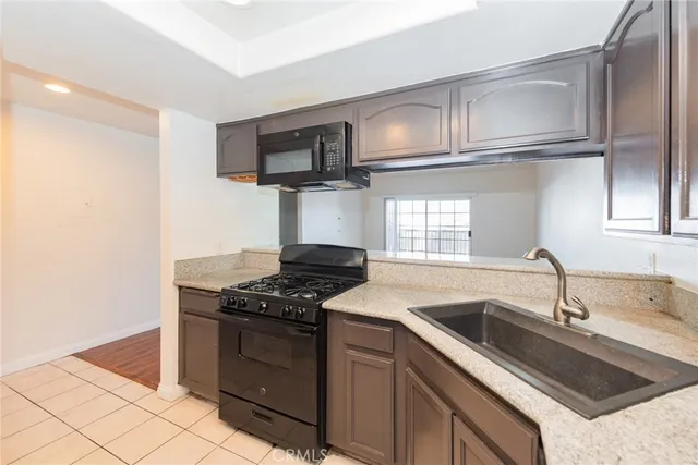 a kitchen with granite countertop a sink stove and microwave