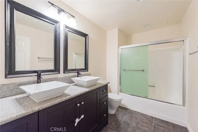 a bathroom with a granite countertop sink mirror and a bathtub