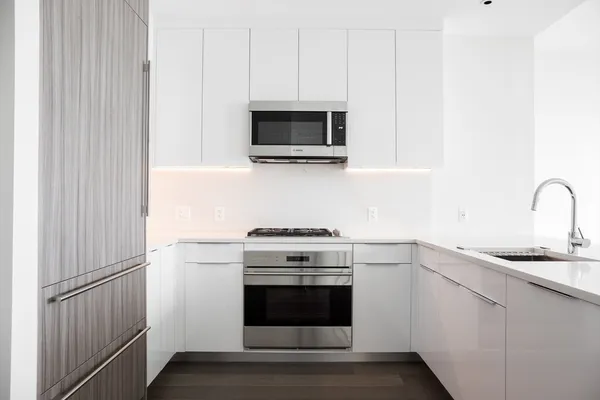 a kitchen with stainless steel appliances granite countertop white cabinets and stove