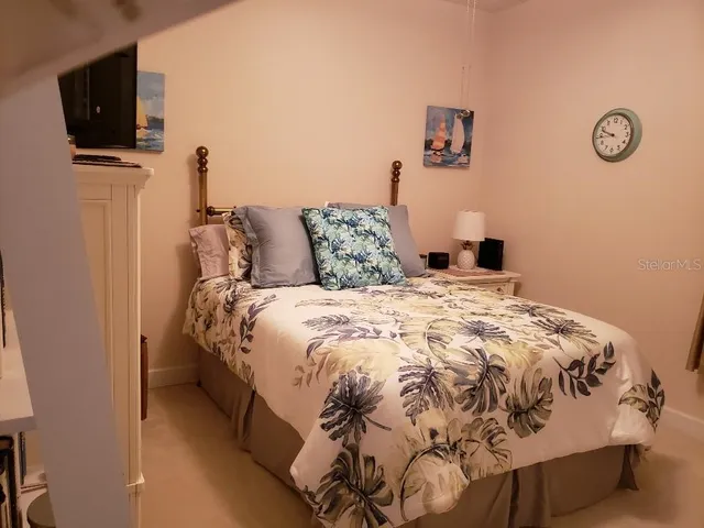 a bed sitting in a bedroom next to a tv and a lamp