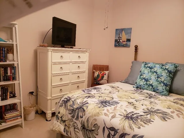 a bedroom with a bed and a television