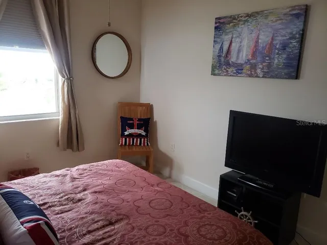 a bedroom with a bed and a television