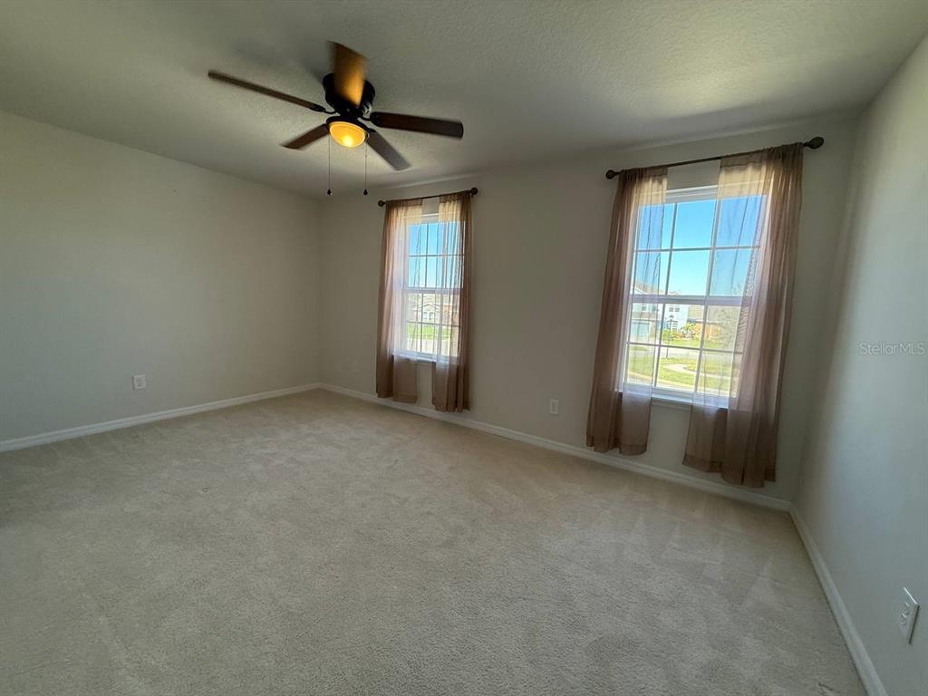 14112 Poke Ridge Drive Riverview, FL 33579 - Photo 17 of 32 an empty room with ceiling fan and windows