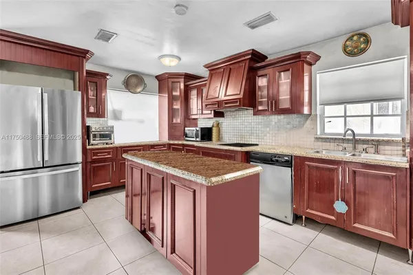 a kitchen with stainless steel appliances granite countertop a stove a refrigerator and a sink