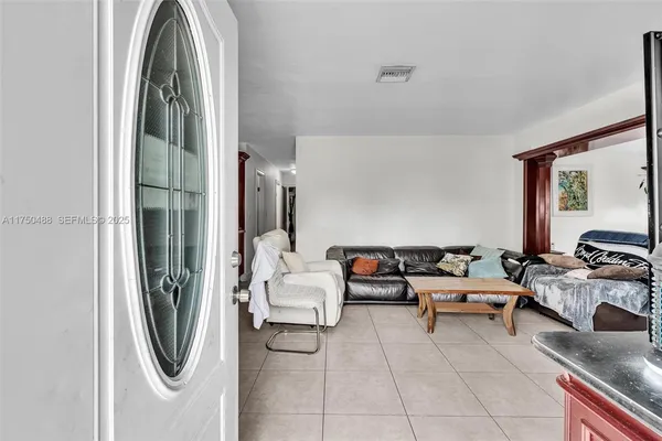 a living room with furniture a rug and kitchen view