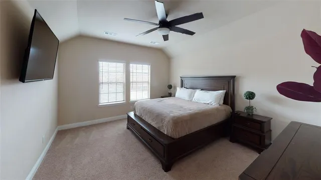 a spacious bedroom with a bed and a flat screen tv