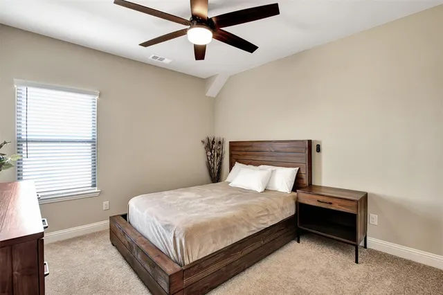 a bedroom with a bed and a ceiling fan