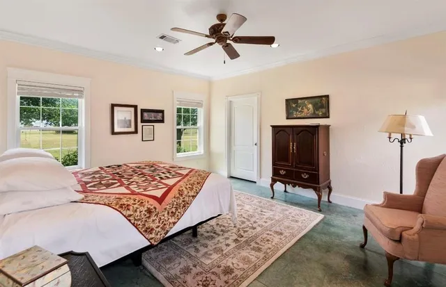 a bedroom with a bed a dresser and a flat screen tv