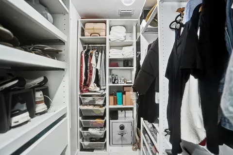 a view of walk in closet with clothes and shoes
