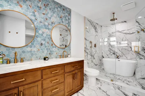 a bathroom with a double vanity sink mirror and toilet