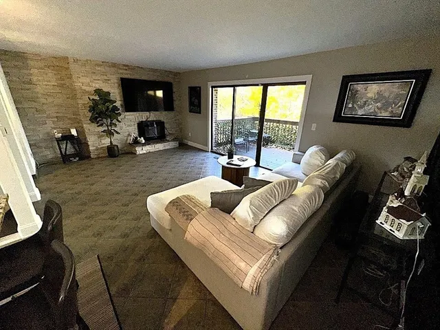 a living room with furniture floor to ceiling window and a flat screen tv