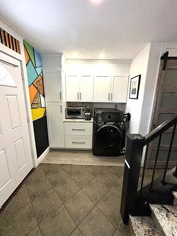 a utility room with cabinets washer and dryer