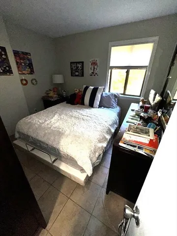 a bed sitting in a bedroom next to a window
