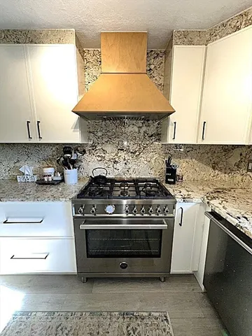 a white stove top oven sitting inside of a kitchen
