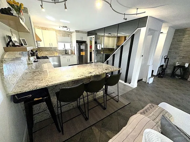 a kitchen with stainless steel appliances granite countertop sink refrigerator and microwave