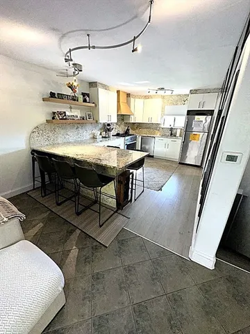 a view of a livingroom with furniture and a kitchen