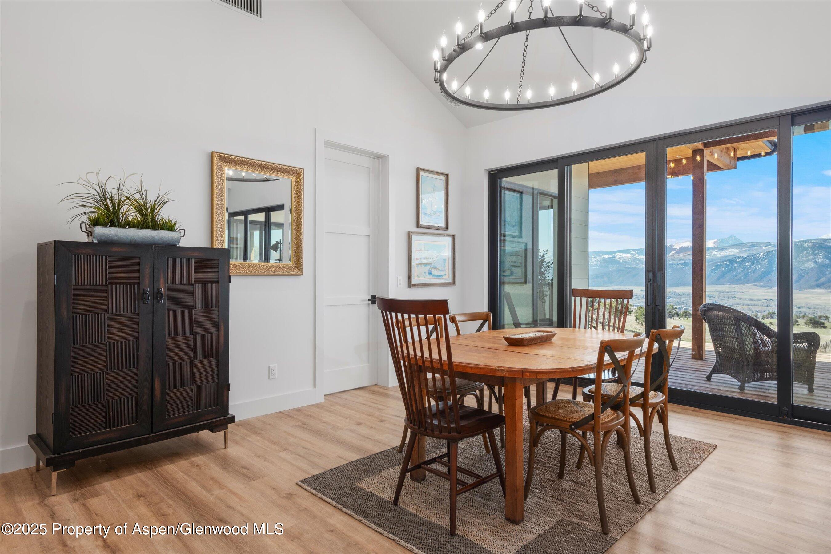 1840 Upper Cattle Creek Road Carbondale, CO 81623 - Photo 11 of 37 a dining room with furniture a chandelier and wooden floor