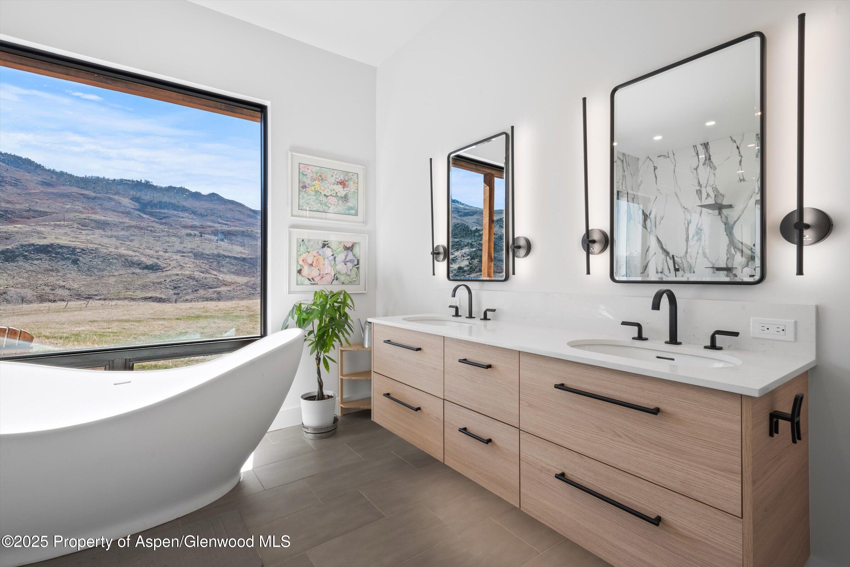 1840 Upper Cattle Creek Road Carbondale, CO 81623 - Photo 18 of 37 a bathroom with a bathtub a sink and a mirror