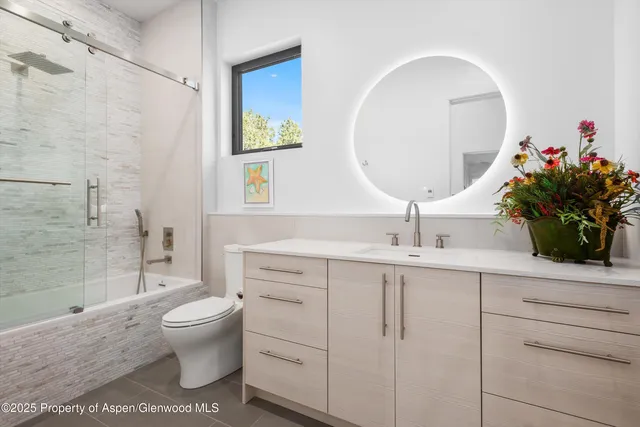 a bathroom with a toilet a sink and mirror