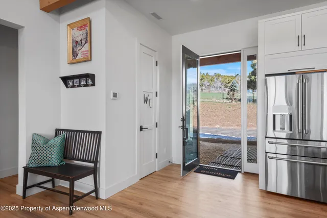 a view of a hallway with wooden floor and a cabinet