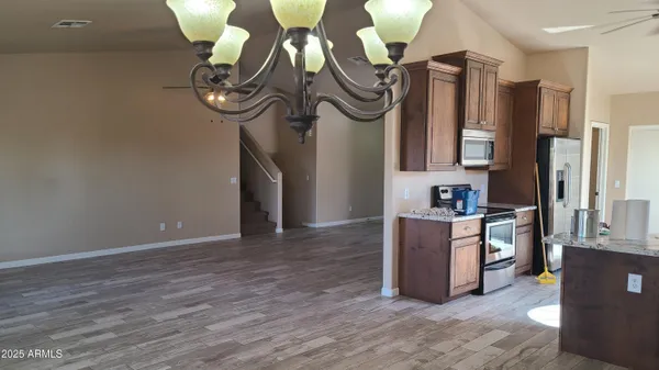 a kitchen with a refrigerator and a wooden floor