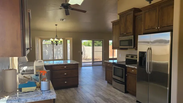 a view of hallway with window and wooden floor