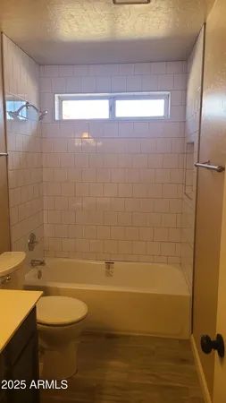 en empty room with windows and chandelier fan