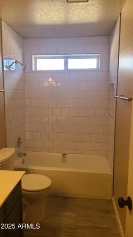 en empty room with windows and chandelier fan