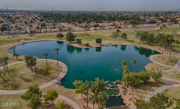 a front view of a house with garden and trees