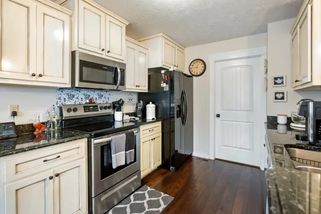 a kitchen with stainless steel appliances granite countertop a stove a refrigerator and a microwave