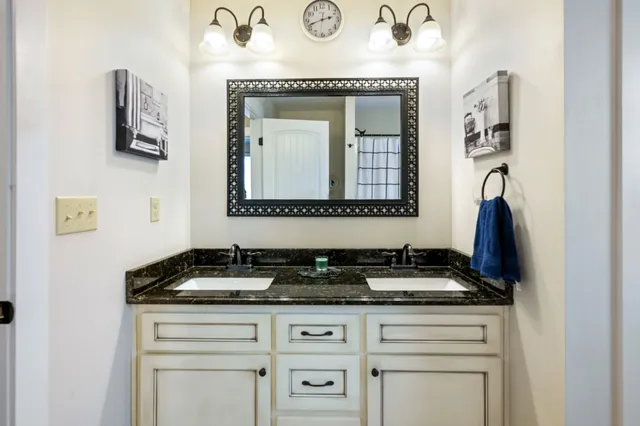 a bathroom with a granite countertop sink and a mirror