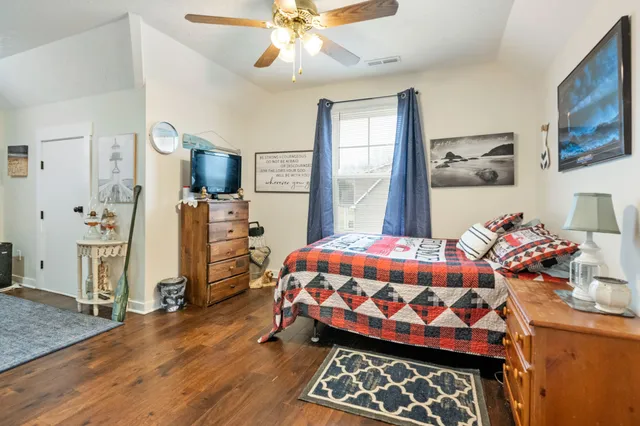 a bedroom with a bed and wooden floor